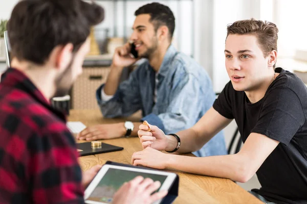 Young man talking to a stockbroker about investing in digital money