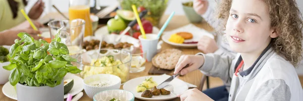 誕生日パーティーの最中にカラフルなテーブルでヘルシーなランチを食べて若い男の子のクローズ アップ — ストック写真