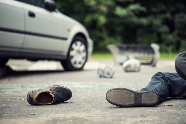 背景にぼやけている車と車の事故の犠牲者の隣に横たわっている靴のクローズ アップ — ストック写真