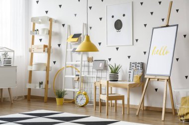 Şövale ve sarı lamba parlak çocuk odası tesis ve saat ile halı üzerinde poster. Gerçek fotoğraf