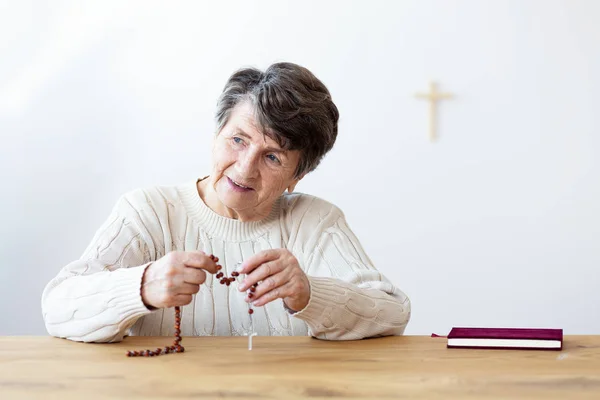 Uśmiechający Się Religijna Babcia Różaniec Siedzi Przy Stole Biblii — Zdjęcie stockowe