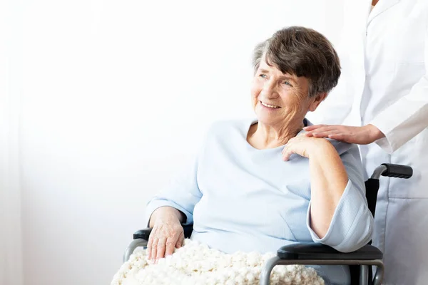 車椅子と介護者支援彼女の幸せの祖母 コピー容量の壁 — ストック写真