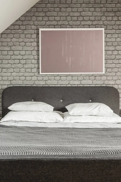 在黑床上方的砖墙上的狗海报 卧室内部有枕头 真实照片 — 图库照片