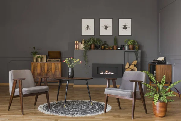 Table Avec Des Fleurs Sur Tapis Entre Fauteuils Gris Dans — Photo