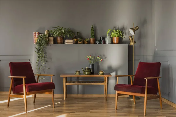 Blumen Auf Einem Holztisch Zwischen Dunkelroten Sesseln Schlichten Grauen Wohnzimmer — Stockfoto