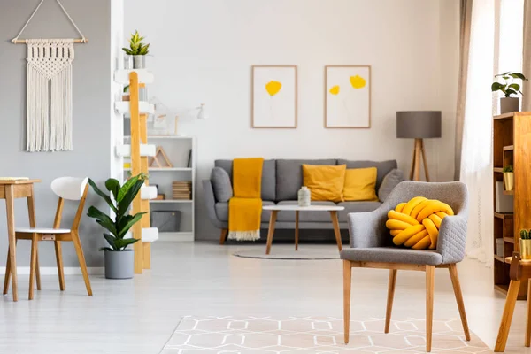 Travesseiro Amarelo Poltrona Cinza Espaçoso Interior Plano Com Cartazes Acima — Fotografia de Stock
