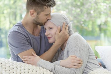 Adam hasta arkadaşını Alnından öpmek. Kanser tedavi kavramı sırasında destek