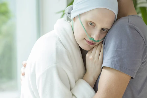 がん化学療法中に彼女の夫を抱いての弱い女性 — ストック写真