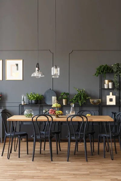 黑色椅子在木桌在灰色饭厅内部与灯和植物 真实照片 — 图库照片