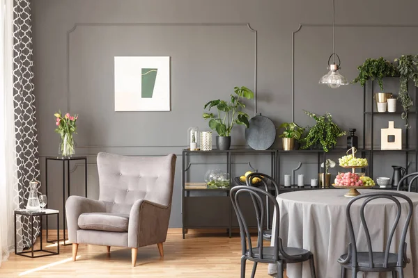 椅子とテーブルとフラット インテリア ポスターで灰色の壁にベージュのアームチェア 実際の写真 — ストック写真