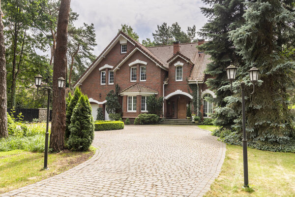 Каменный подъезд к дому в английском архитектурном стиле в лесу. Настоящее фото
