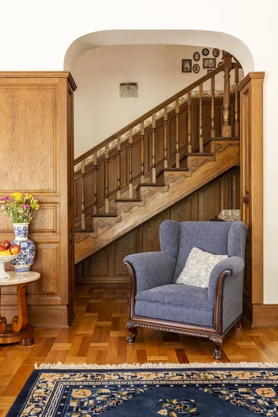 Blauer Sessel Gegen Holztreppe Klassischen Wohnzimmerinterieur Mit Blumen Und Teppich — Stockfoto