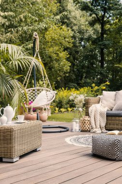 Gerçek fotoğraf asılı bir yazlık ev ahşap bir teras üzerinde sandalye ve rattan mobilya