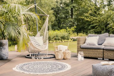 Yastık ile yuvarlak halı ve rattan koltuk bahçedeki terasta hamak üzerinde. Gerçek fotoğraf