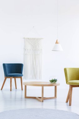 Tablo arasında beyaz salon iç lamba ile mavi ve sarı koltuğa. Gerçek fotoğraf