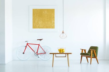 Yukarıda yeşil koltuk ve bisiklet üzerinde sarı boya ile beyaz düz iç ahşap masa lambası. Gerçek fotoğraf
