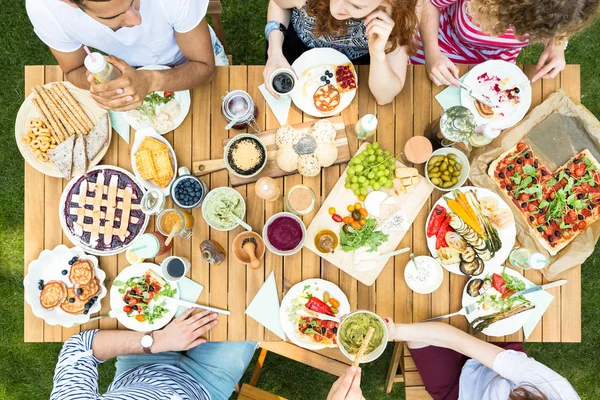 庭で友達のパーティーの最中にイタリア料理と木製のテーブルの上から見る — ストック写真