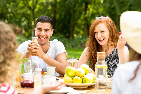 Jóvenes Sentados Jardín Bebiendo Agua Comiendo Fruta Riendo — Foto de Stock