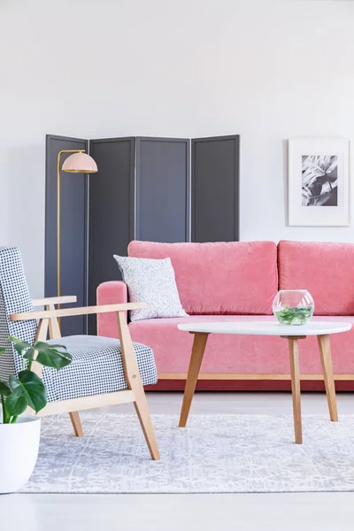 Gemusterter Holzsessel Neben Tisch Und Rosa Sofa Wohnzimmerinterieur Mit Poster — Stockfoto