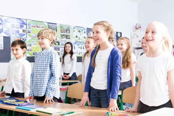 笑顔の女の子と男の子の音楽の授業中に教室で歌を歌って — ストック写真