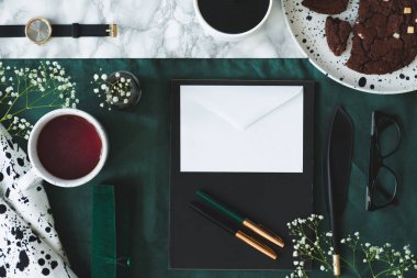 Gözlük yeşil zemin üzerine beyaz zarf yanında çay en iyi görünümü. Metniniz için boş bir alanı ile gerçek fotoğraf