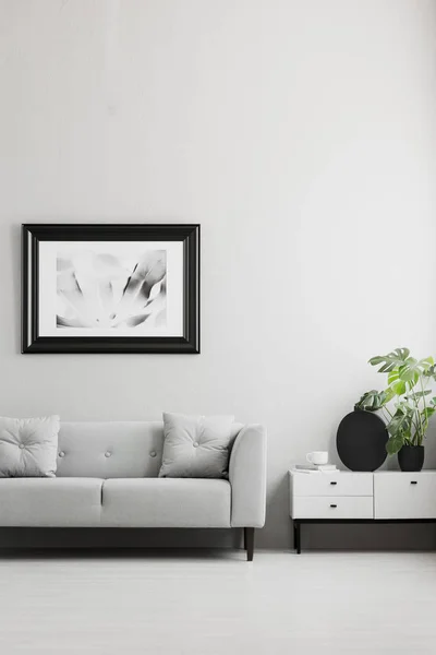 照片在一个黑色的 厚的框架在灰色的墙壁上 白色的餐具柜和一个舒适的沙发在一个时髦的客厅内部与地方的咖啡桌 真实照片 — 图库照片