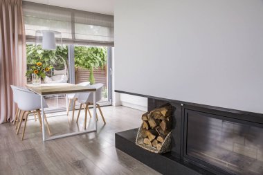 Şömine parlak yemek odası iç pencere ile masada beyaz sandalye yanında. Gerçek fotoğraf