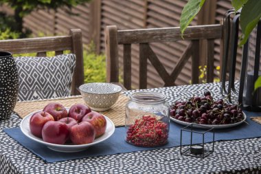 Elma, kiraz ve kuş üzümü evin terasında masada. Gerçek fotoğraf