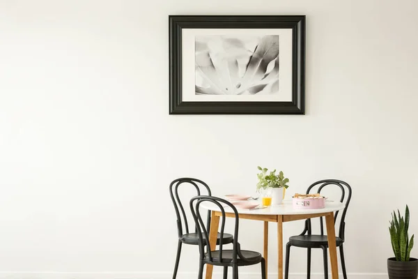 Echtes Foto Eines Gedeckten Esstisches Mit Schwarzen Stühlen Und Malerei — Stockfoto