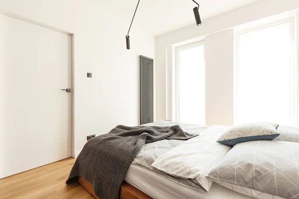 枕と毛布の窓とドアの白い寝室のインテリアでベッドの上 実際の写真 — ストック写真