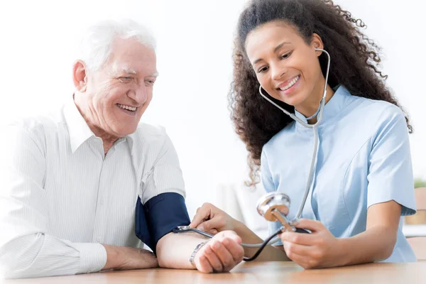 Lachende Arts Met Stethoscoop Onderzoekt Gelukkig Bejaarde Man Het Ziekenhuis — Stockfoto