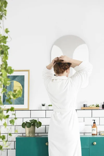 Женщина Белом Халате Перед Зеркалом Салоне Ванной Комнаты Растением Плакатом — стоковое фото