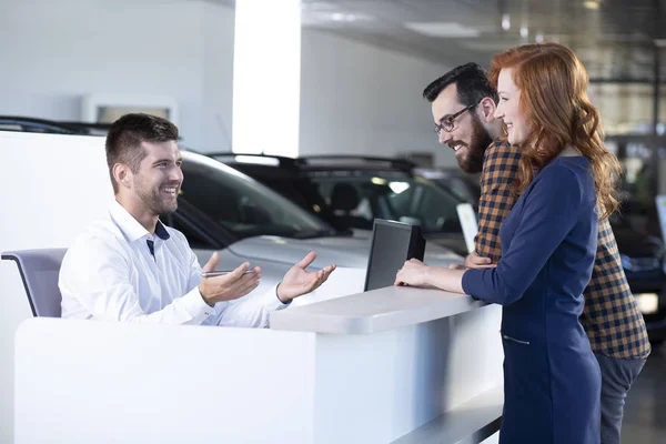 Lächelnder Autoverkäufer Gespräch Mit Zufriedenen Käufern Exklusiven Showroom — Stockfoto