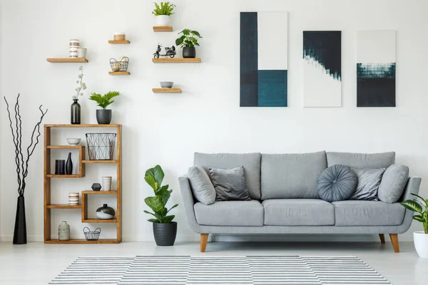 Elegante Wohnzimmereinrichtung Mit Grauem Sofa Holzregalen Pflanzen Und Gemälden Der — Stockfoto