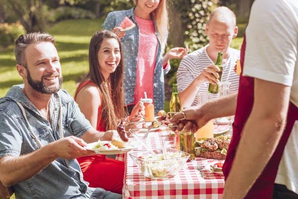 Amigos Sonrientes Comiendo Comida Parrilla Durante Fiesta Cumpleaños Jardín —  Fotos de Stock