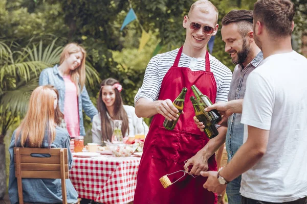 Happy men cheering during garden party with friends