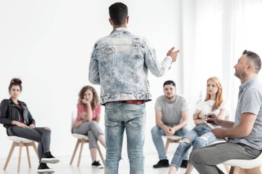 Denim kıyafeti sorunları olan genç bir grup terapisi sırasında konuşan genç adam