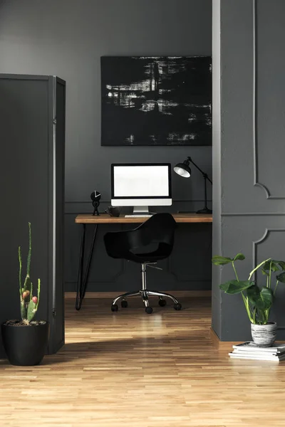 在自由职业者的房间内部的台式计算机样机与黑色绘画和植物 真实照片 — 图库照片
