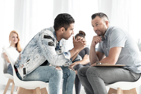 Spanish teenager talking to a counselor about problem of alcohol addiction