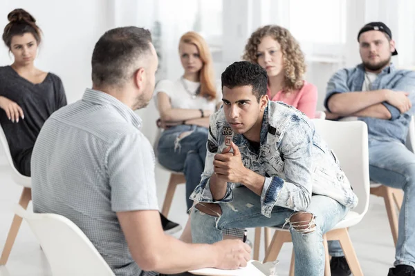 Opstandige Spaanse Man Luisteren Naar Psycholoog Tijdens Groepstherapie Voor Tieners — Stockfoto