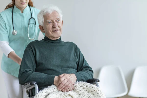 医生与听诊器支持生病的老人在轮椅上的医院 — 图库照片