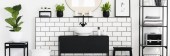 Real photo of black and white bathroom interior with fresh green plants, metal rack with towels and candles placed under mirror