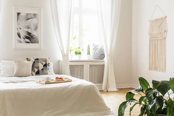 朝食のペストリーと植物と窓の下枠側の席の明るく静かな寝室のインテリアで居心地の良い 白いベッドの上のコーヒー トレイ — ストック写真