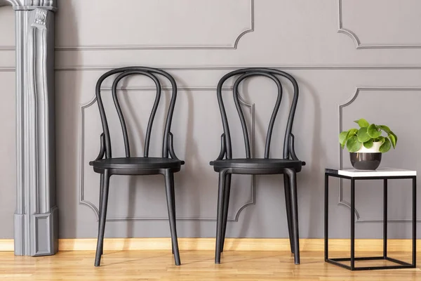 Dwa Czarne Krzesła Stojące Obok Marmuru Koniec Tabeli Świeżych Roślin — Zdjęcie stockowe