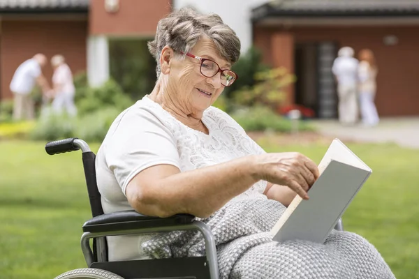 Glückliche Behinderte Seniorin Rollstuhl Liest Buch — Stockfoto