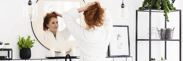 Young Woman Tying Her Hair Bright Bathroom Interior Black Furniture — Stock Photo, Image