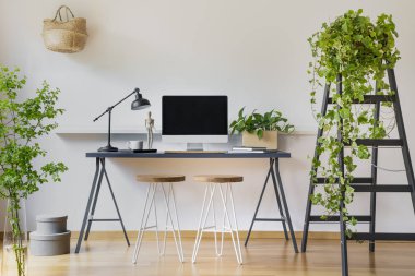 Beyaz duvarları ve bir öğrenci için çalışma alanı ile modern bir iç ahşap merdiven sarmaşık bitki ile masa üstünde bilgisayar
