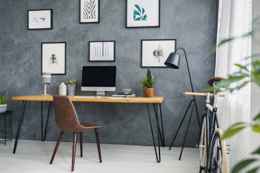 Gri serbest meslek Danışma, kahverengi sandalye iç lamba ve Galeri posterleri ile. Gerçek fotoğraf