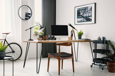Sandalye Masa ev ofis iç saat ve poster ile masaüstü bilgisayar ile. Gerçek fotoğraf