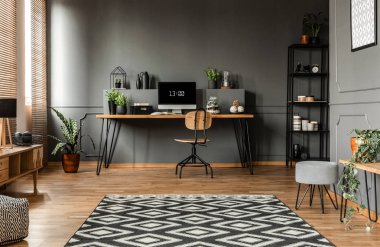 Geniş gri oturma odası iç bilgisayar monitörü masası, sandalye ile desenli halı